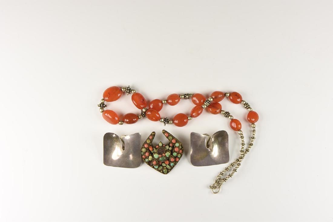Vintage Jewellery Group: 20th century AD. A mixed group comprising: a necklace of carnelian(? beads and white metal spaers; two clip earrings, each a sculpted plaque; a lozengiform brooch with inset turquoise and other beads.