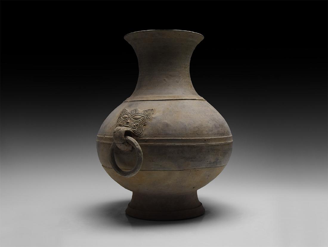 Chinese Han Hu Jar with Handles: Han Dynasty, 206 BC-220 AD. A large ceramic bicolour vessel with pear-shaped bulbous body with flared base, tall neck with wide flared rim, raised circumferential band below the neck and to the body; 