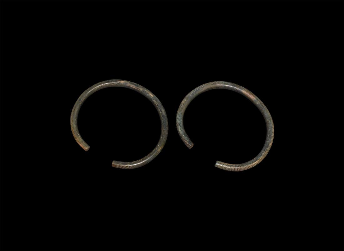 Bronze Age Decorated Arm-Ring Pair: 2nd millennium BC. A matching pair of large arm-rings, both decorated with incised lines to the upper face with three bands of hatched lines in between. 241 grams total, 11.2cm each (4 1/4"). From a p