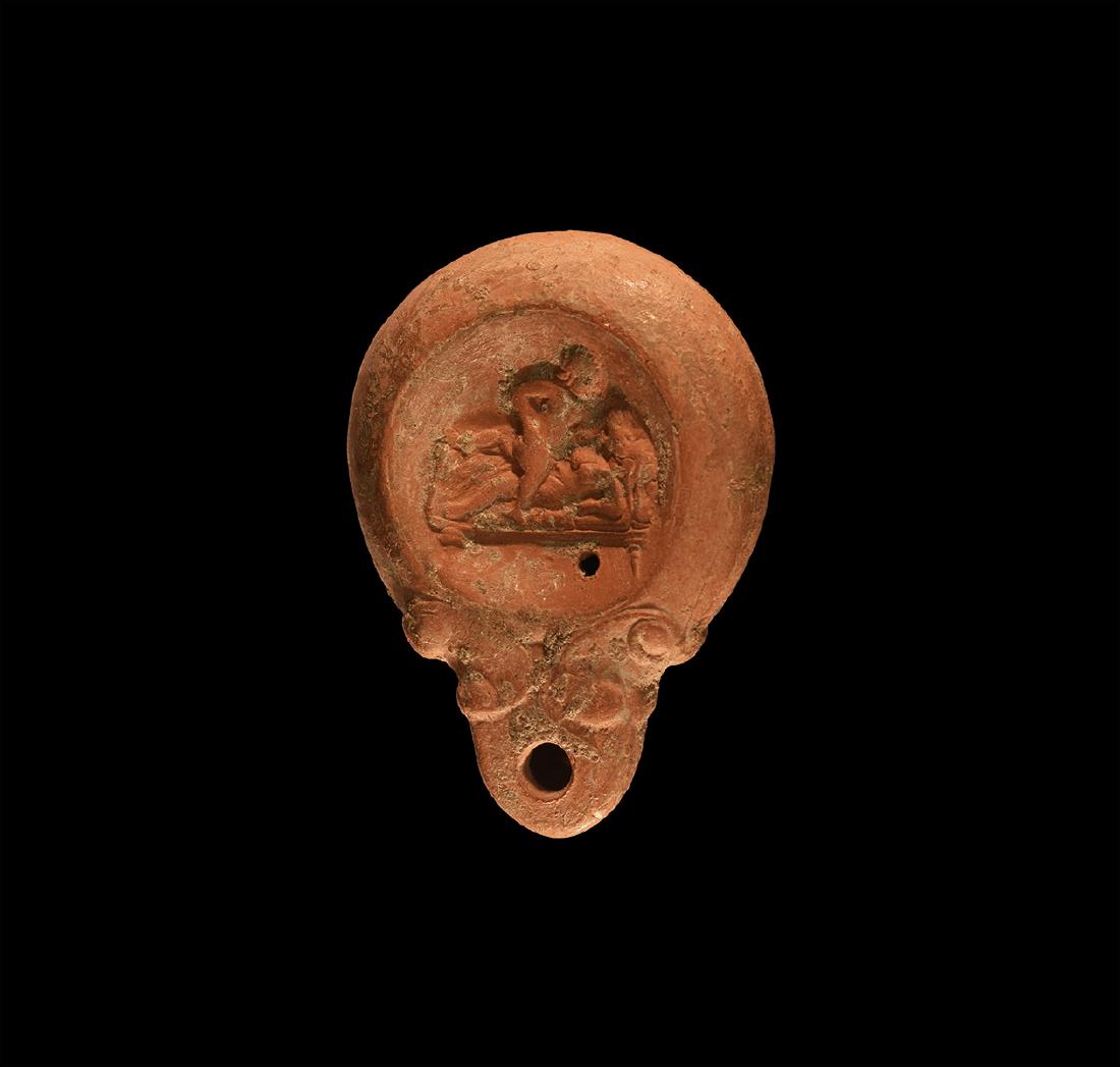 Roman Oil Lamp with Erotic Scene: 2nd-3rd century AD. A ceramic oil lamp with rounded nozzle, pelta motifs to the sides; the discus with an erotic scene of two nude females on a bed. 95 grams, 95mm (3 3/4"). Property of a London gentl