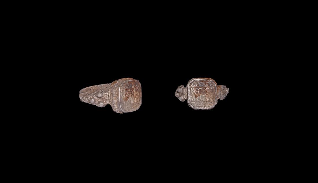 Byzantine Ornamented Silver Ring: 10th-12th century AD. A silver ring with D-section hoop, bosses to the shoulders, square bezel with beaded borders, pointillé and linear geometric ornament. 8.36 grams, 25.72mm overall, 20.25mm inter
