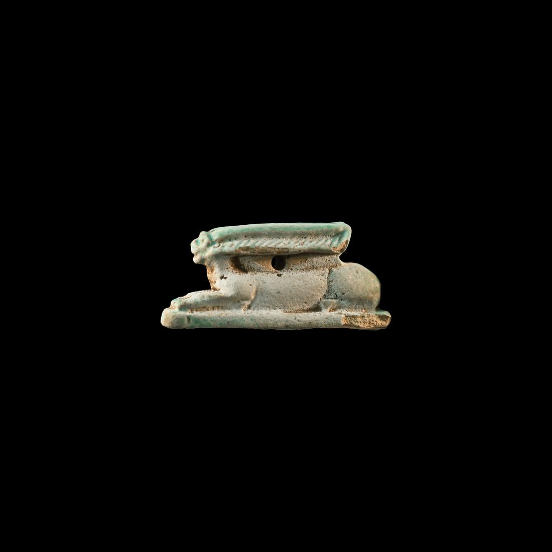 Egyptian Amulet of a Hare: Late Dynastic Period, 664-332 BC. A substantial pale green glazed composition amuletic figure of a crouching hare on a rectangular base, rib detailing to the ears, pierced for suspension. 5.52 grams, 