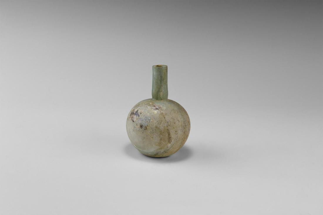 Roman Glass Vessel: 1st century AD. An aqua glass vase or toilet bottle with bulbous body, dimple base, tubular neck. 26 grams, 95mm (3 3/4"). Property of a Bristol collector; formerly part of his father's collection for
