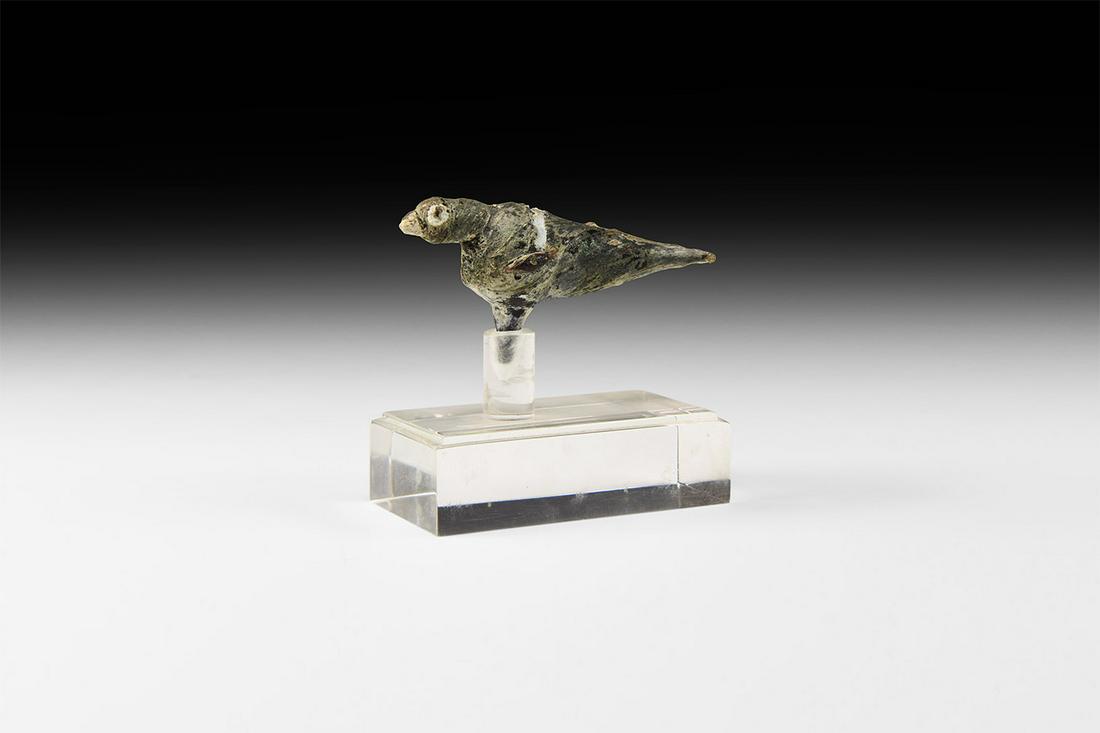 Roman Glass Bird Figurine: 1st-4th century AD. A glass figure of a bird with white trail pattern to the eyes, beak and back; trail wings to the side with fan-tail to back, tine to base; mounted on a custom-made stand. 12 grams,