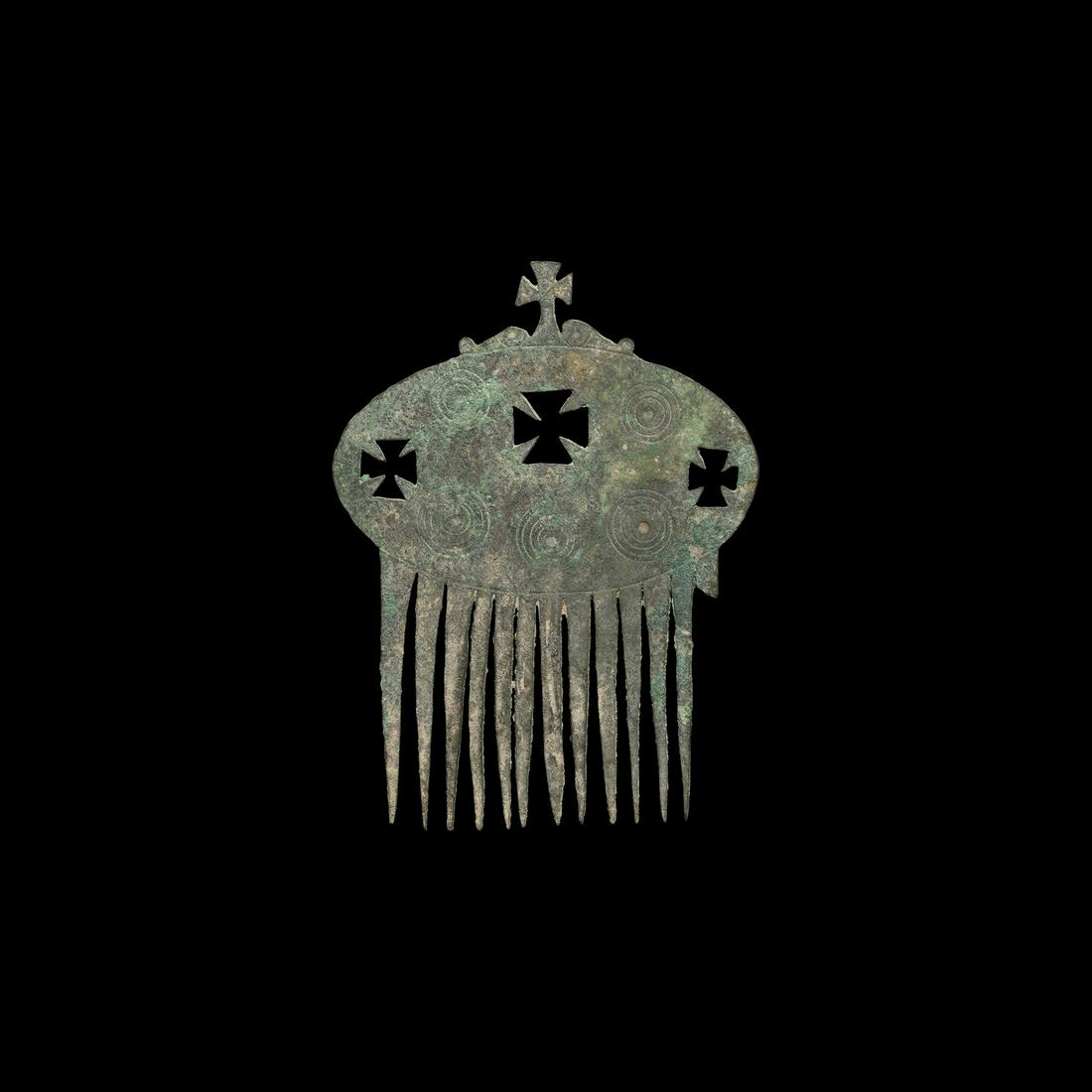 Byzantine Comb with Crosses: 5th-7th century AD. A bronze hair comb with coarse-cut tines, ovoid plaque with three cruciform voids, incised concentric rings to the obverse, cross and scrolls above. 23.5 grams, 80mm (3"). Property