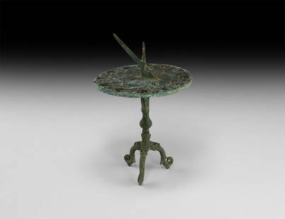 Korean Calligraphic Sundial: 18th century AD or earlier. A bronze sundial with horizontal disc table and two-part gnomon, balustered stem and tripod feet with dragon-head detailing; the table with silver-inlaid gridlines and band