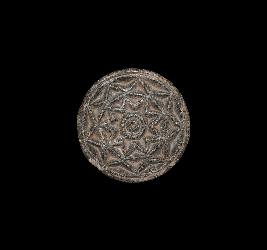 Gandharan Carved Roundel: 1st century AD or later. A carved serpentine plano-convex roundel with high-relief rosette to the flat face. 300 grams, 96mm (3 3/4"). Property of a Middlesex collector; acquired on the London art mar