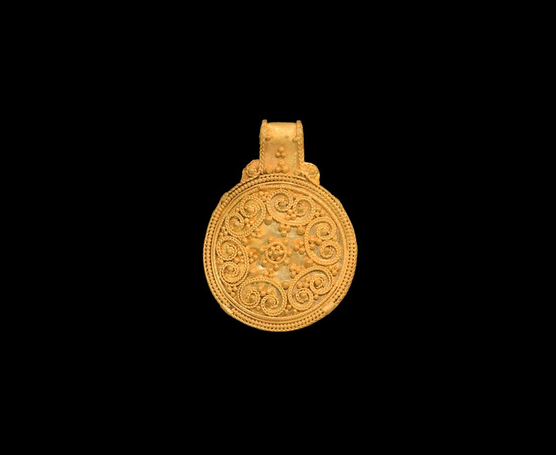 Viking Gold Filigree Scroll Pendant: 10th-12th century AD. A gold disc pendant with integral loop, applied filigree volute scrolls and granulation. 4.87 grams, 32mm (1 1/4"). From a London W1, UK, collection; acquired on the German art m
