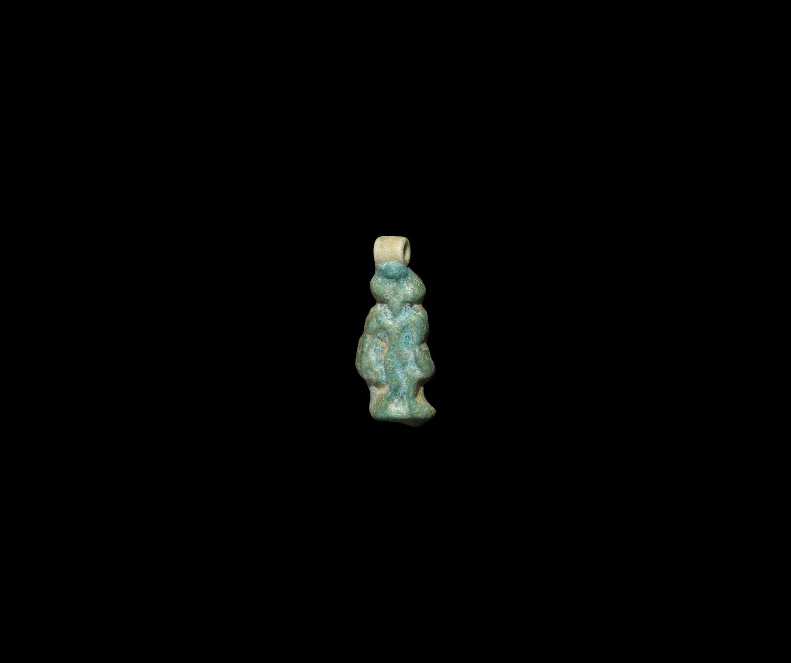 Egyptian Tyet Amulet: New Kingdom, Amarna Period, 1352-1336 BC. A blue glazed composition Tyet amulet with looped top and arms hanging down by the side; suspension ring to the top. See Andrews, C. Amulets of Ancient Egypt,