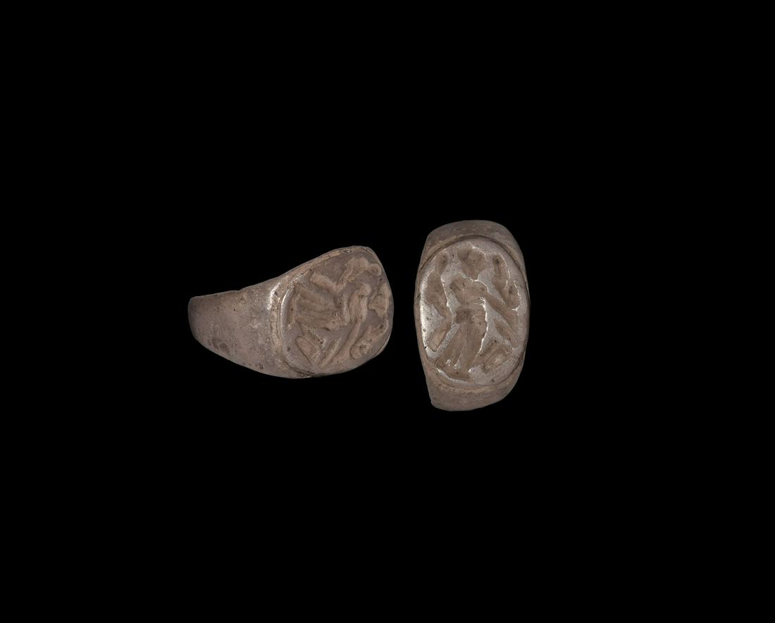 Roman Silver Signet Ring with Standing Figure: 1st-3rd century AD. A silver ring with expanding D-section hoop, raised discoid bezel with intaglio image of a standing female, flowing cornucopia behind. 4.9 grams, 20.10mm overall, 15.26mm internal 