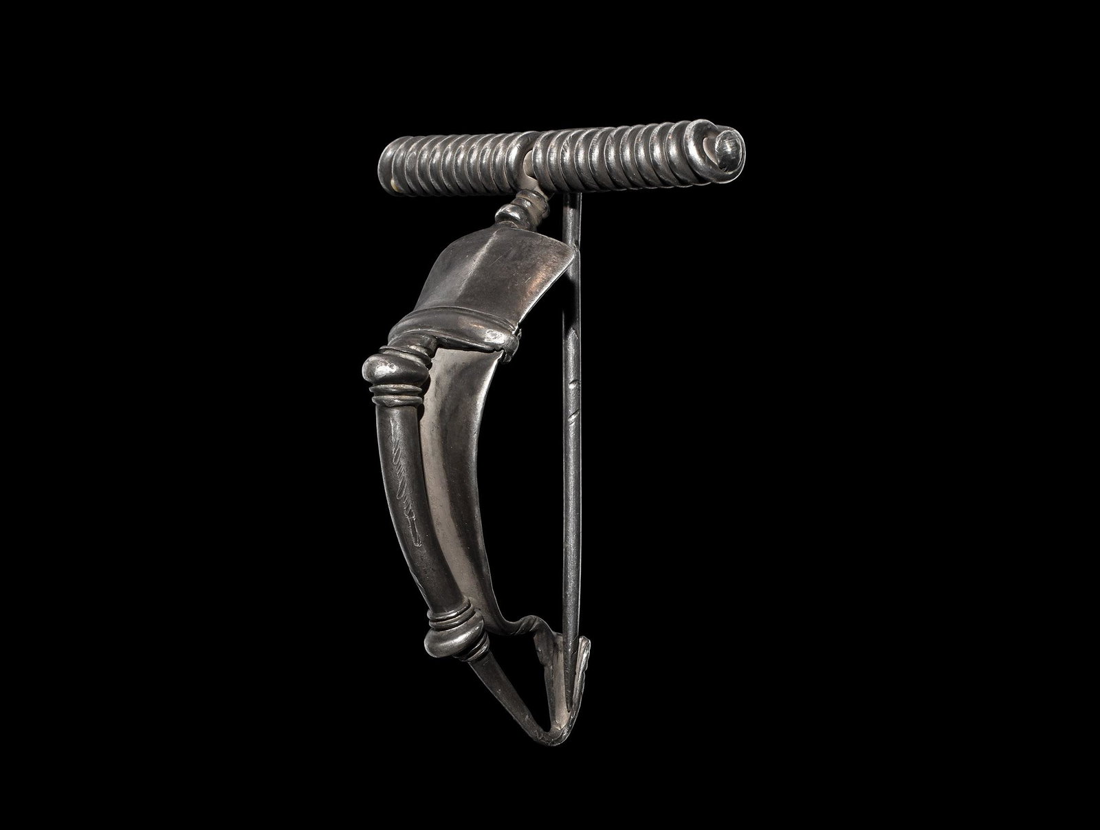 Large Roman Silver Bow Brooch: 2nd-3rd century AD. A substantial silver P-shaped bow brooch with external coiled spring and pin, curved triangular bow with short foot and returned finial with collars and lateral clips. Cf. Hattatt,