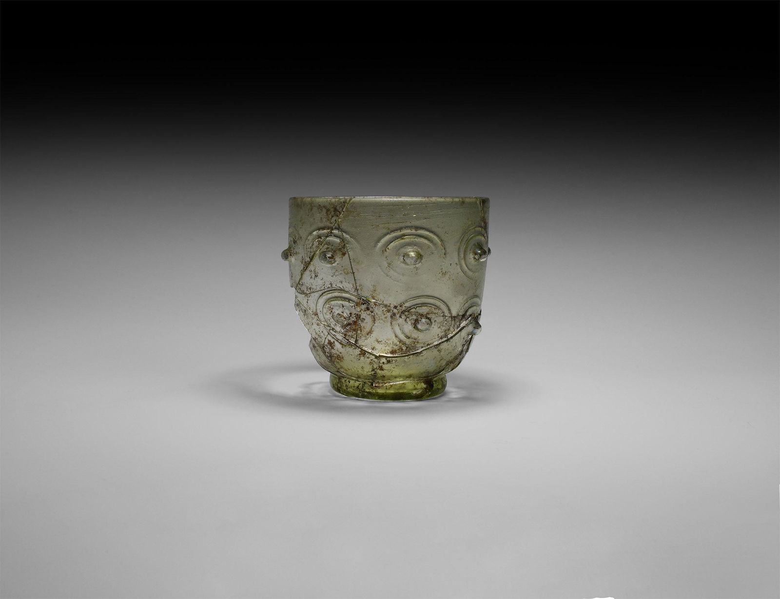 Roman Fragment Glass Cup: 3rd-4th century AD. A fragmentary pale green squat beaker with barrel-shaped body, applied trail to the base and rim. 103 grams, 9.5cm (3 3/4"). From a private collection; previously in an old central
