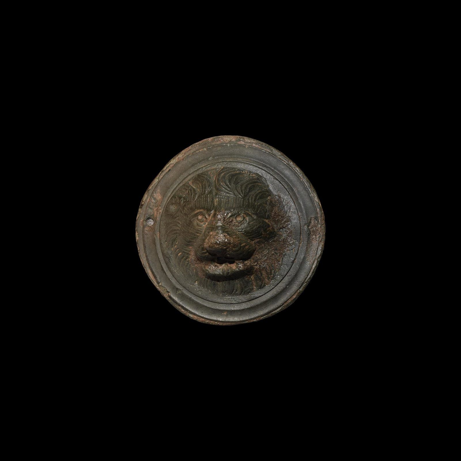 Roman Lion-Head Mount: 1st-2nd century AD. A bronze disc mount with substantial rear stud, domed centre formed as a lion's mask with hole to the mouth, concentric rings to the border. 115 grams, 71mm (2 3/4"). From a privat
