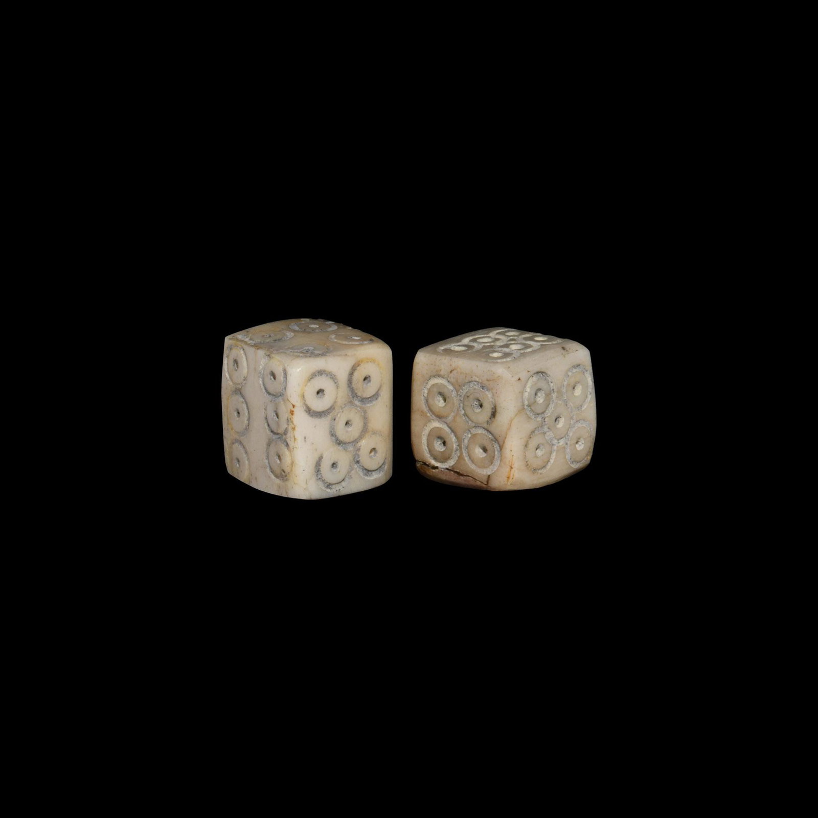 Roman Bone Dice Pair: 1st-4th century AD. A matched pair of cuboid bone dice with ring-and-dot markings disposed 1:6, 2:4, 3:5. 1.64 grams total, 7-8mm (1/4"). Property of a gentleman; acquired in the late 1960s-early 1970