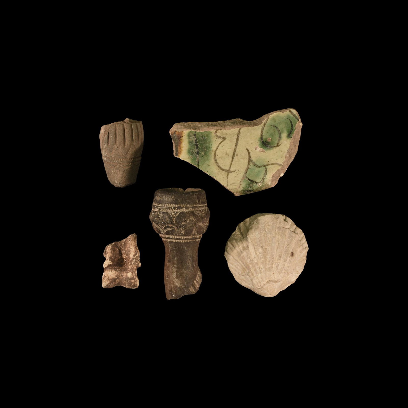 Islamic Artefact Group: 14th-18th century AD. A mixed group including glazed ceramic fragments, a sheep's astragalus, a pipe fragment and a fossil bivalve shell. 92 grams total, 27-65mm (1 - 2 1/2"). Ex an important Dutch co