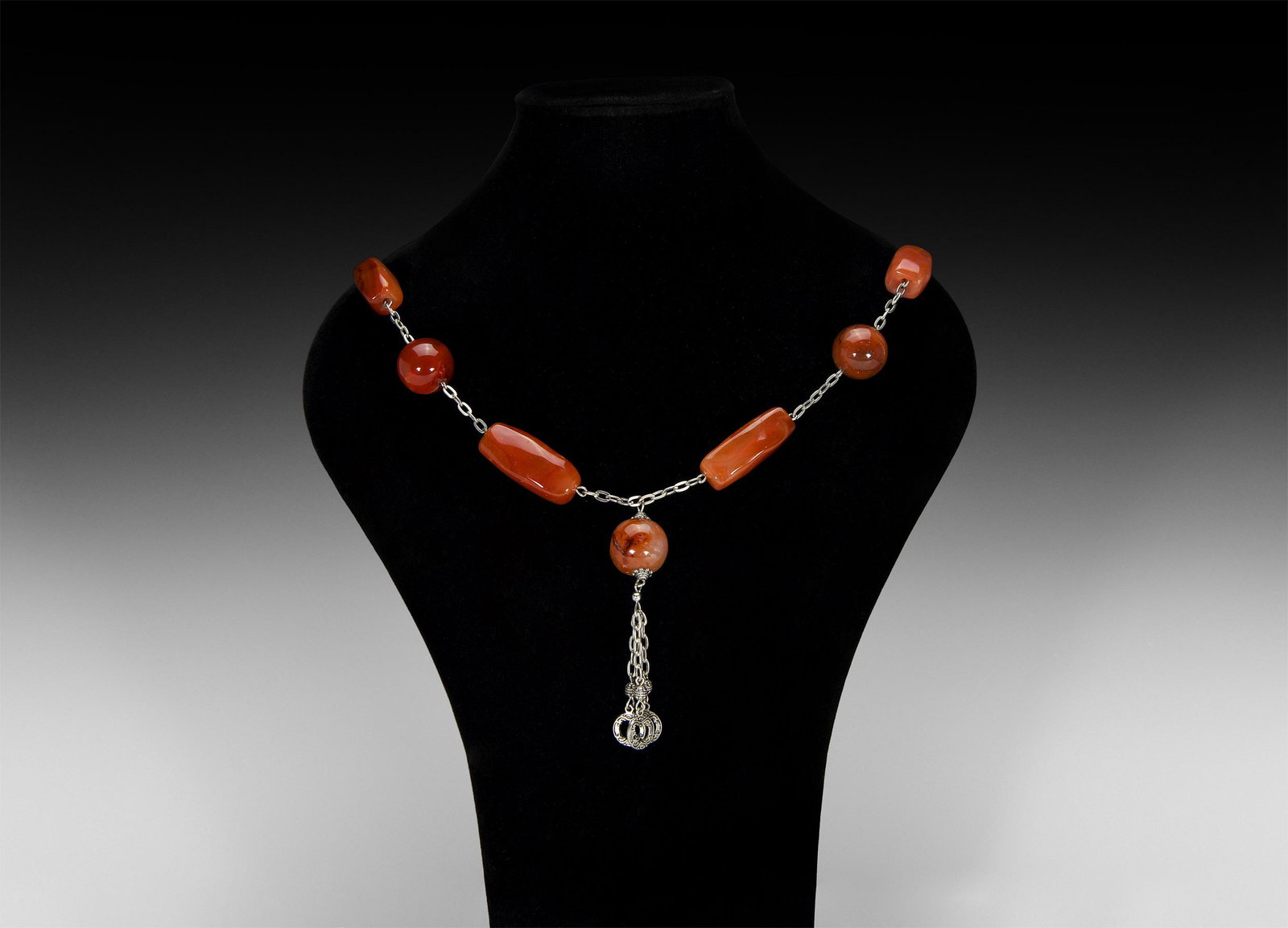 Carnelian Bead Necklace: A necklace of six spherical and square-section carnelian beads with silver-coloured metal chains, spherical carnelian bead with three dangles. 149 grams, 68cm (26 3/4"). From a private European collec