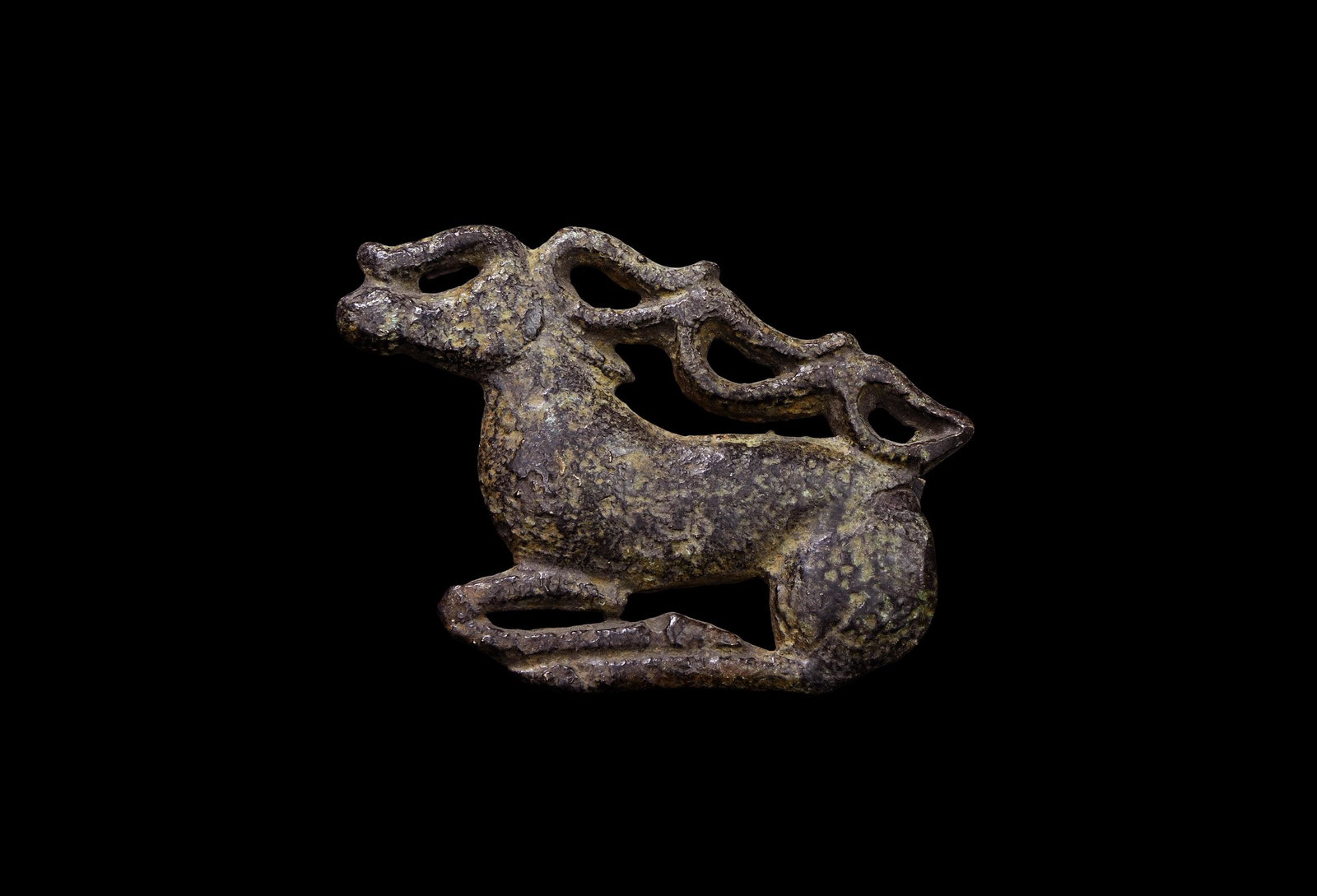 Scythian Galloping Stag Mount: 6th-2nd century BC. A bronze mount of a galloping stag with its long legs folded beneath the body, large looped antlers resting against the back; two attachment studs to the reverse. 54.3 grams, 70mm 