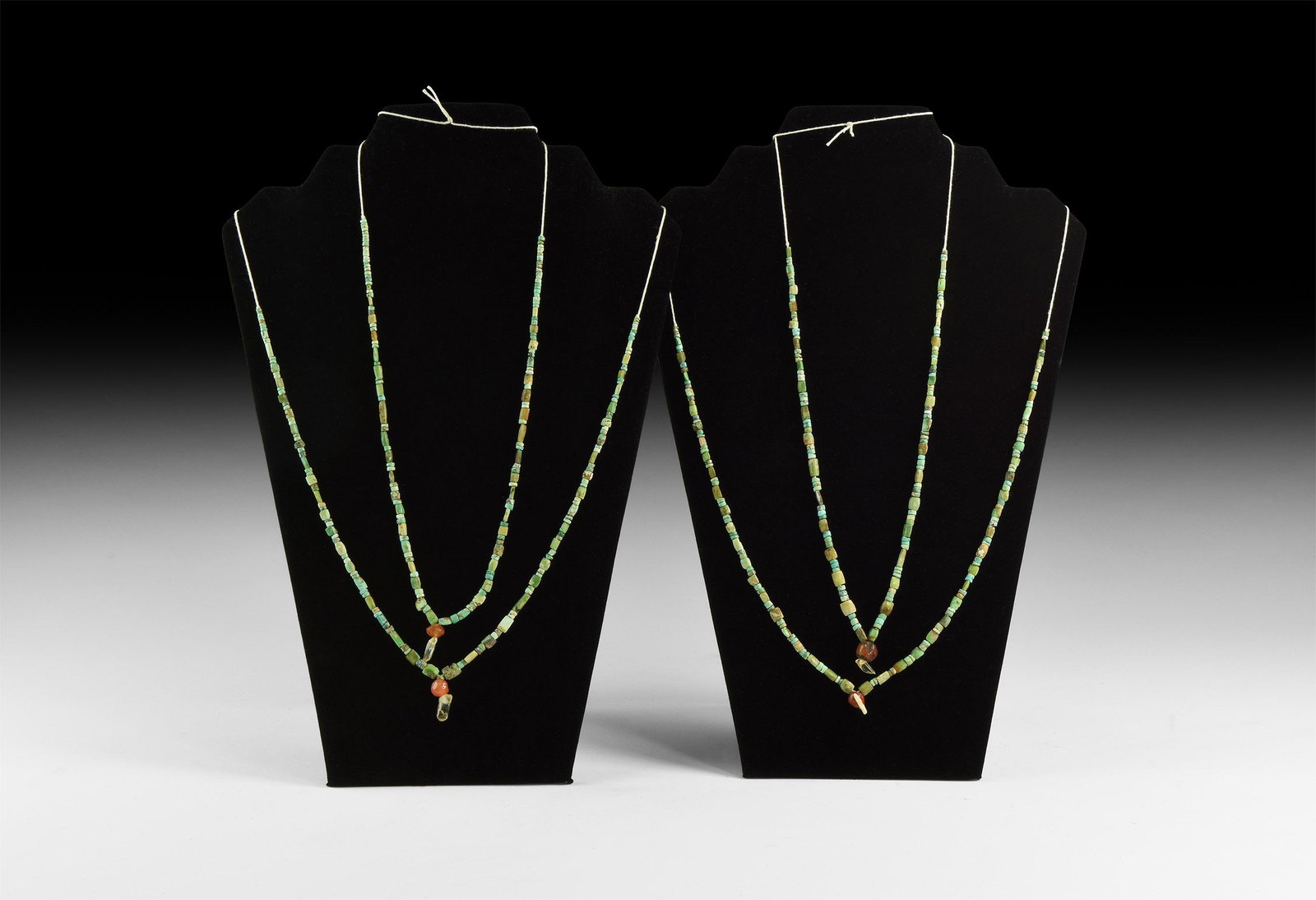 Roman Turquoise Bead Necklace String Group: 1st-4th century AD and later. A group of four turquoise and turquoise-coloured bead necklace strings composed of annular and barrel-shaped beads, three with central drop of carnelian and rock crystal 