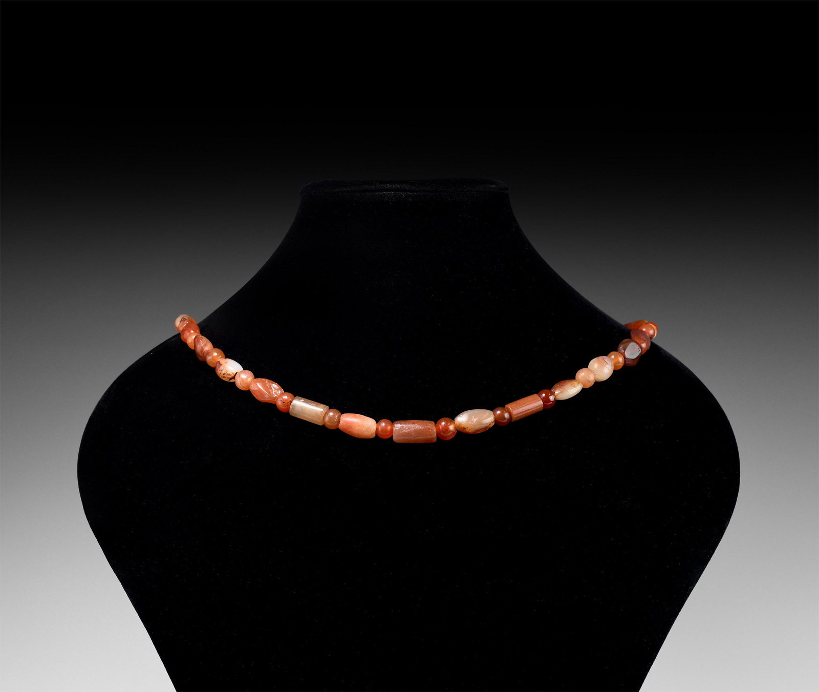 Roman Carnelian Bead String: 1st-3rd century AD or later. A restrung necklace of graduated spherical, oblate and cylindrical carnelian beads, modern clasp. 40.5 grams, 40cm (16"). Property of a West London gentleman; his collecti