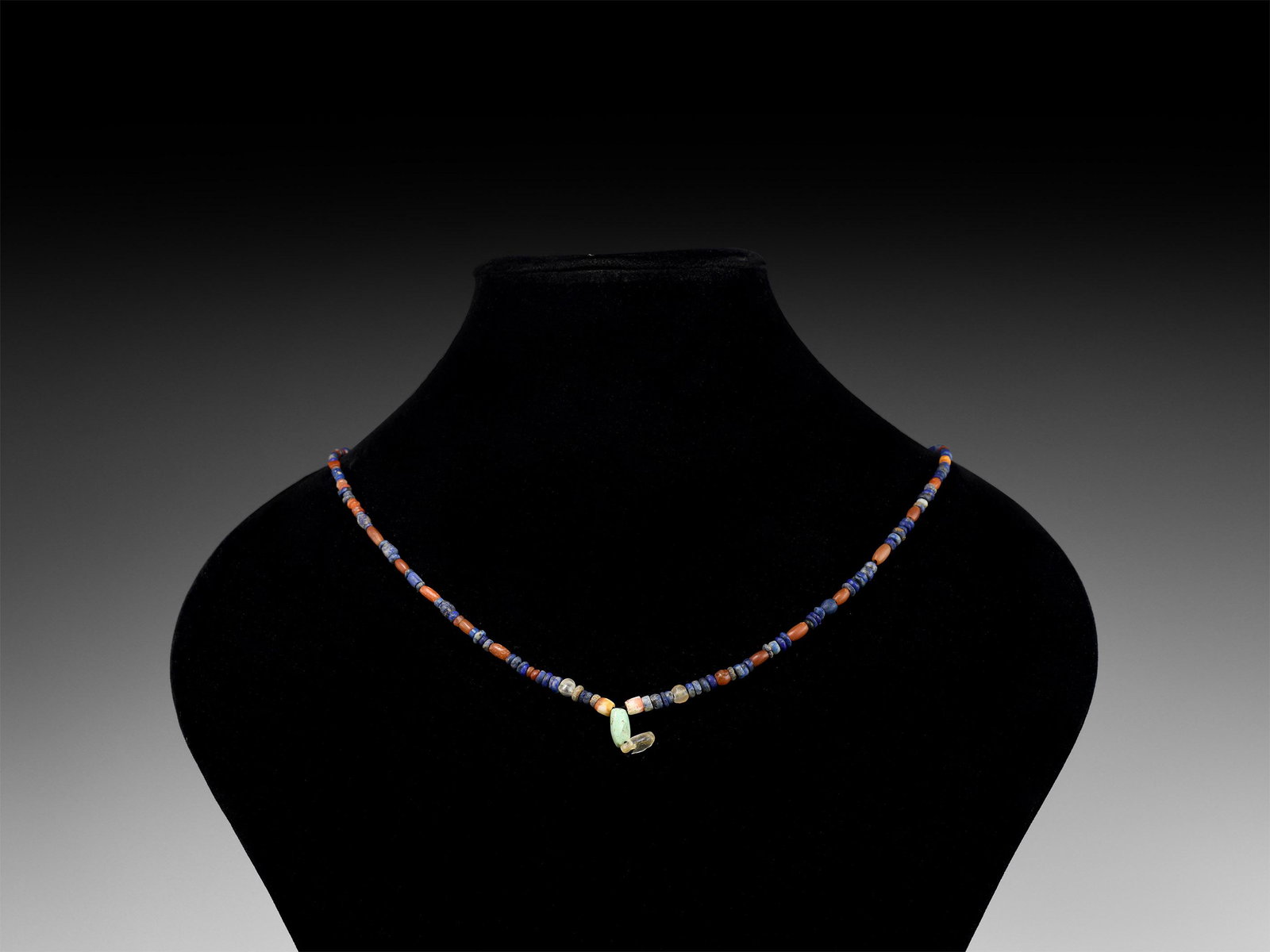 Roman Mixed Stone Bead Necklace String: 1st-3rd century AD. A restrung necklace of carnelian, lapis lazuli and other beads with turquoise and rock crystal dangle centrepiece. 9.2 grams, 37cm (14 1/2"). Property of a West London gentleman; h