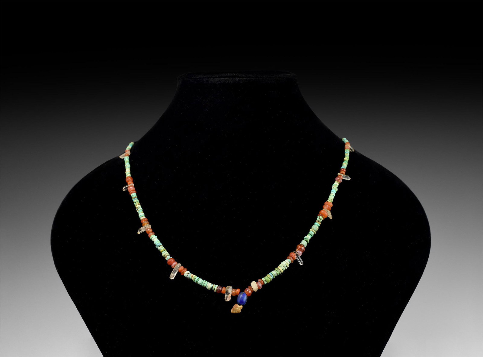 Roman Mixed Stone Bead Necklace String: 1st-3rd century AD and later. A restrung designer necklace of turquoise and carnelian annular beads with rock crystal dangles, agate bead and arrowhead pendant. 12.1 grams, 36cm (14 1/4"). Property of