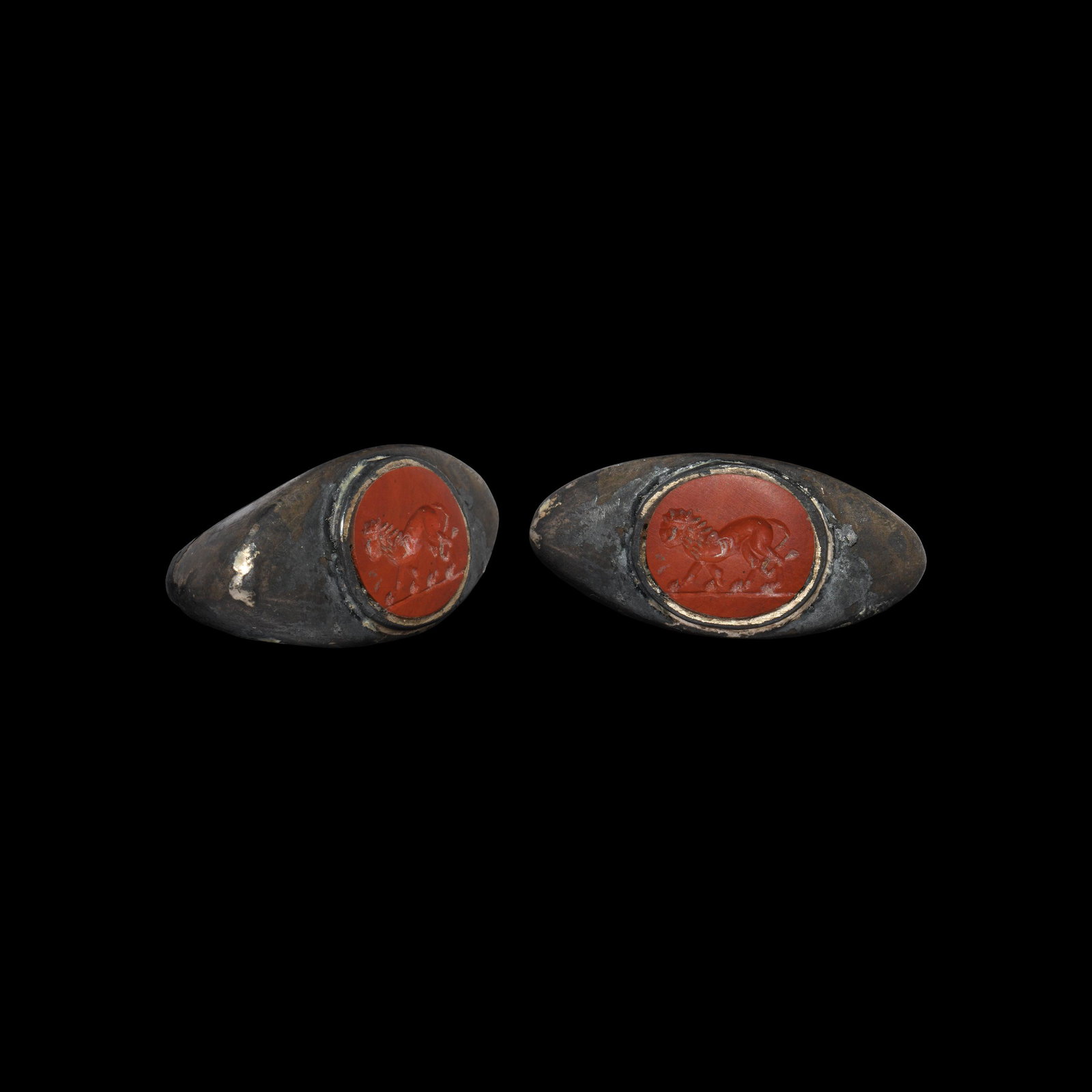Roman Silver Ring with Lion Gemstone: 3rd century AD. A substantial silver ring, a marriage of a D-section hoop with expanding shoulders, flat scaphoid plaque with inset red jasper intaglio, engraved with an advancing lion on a baseline. 