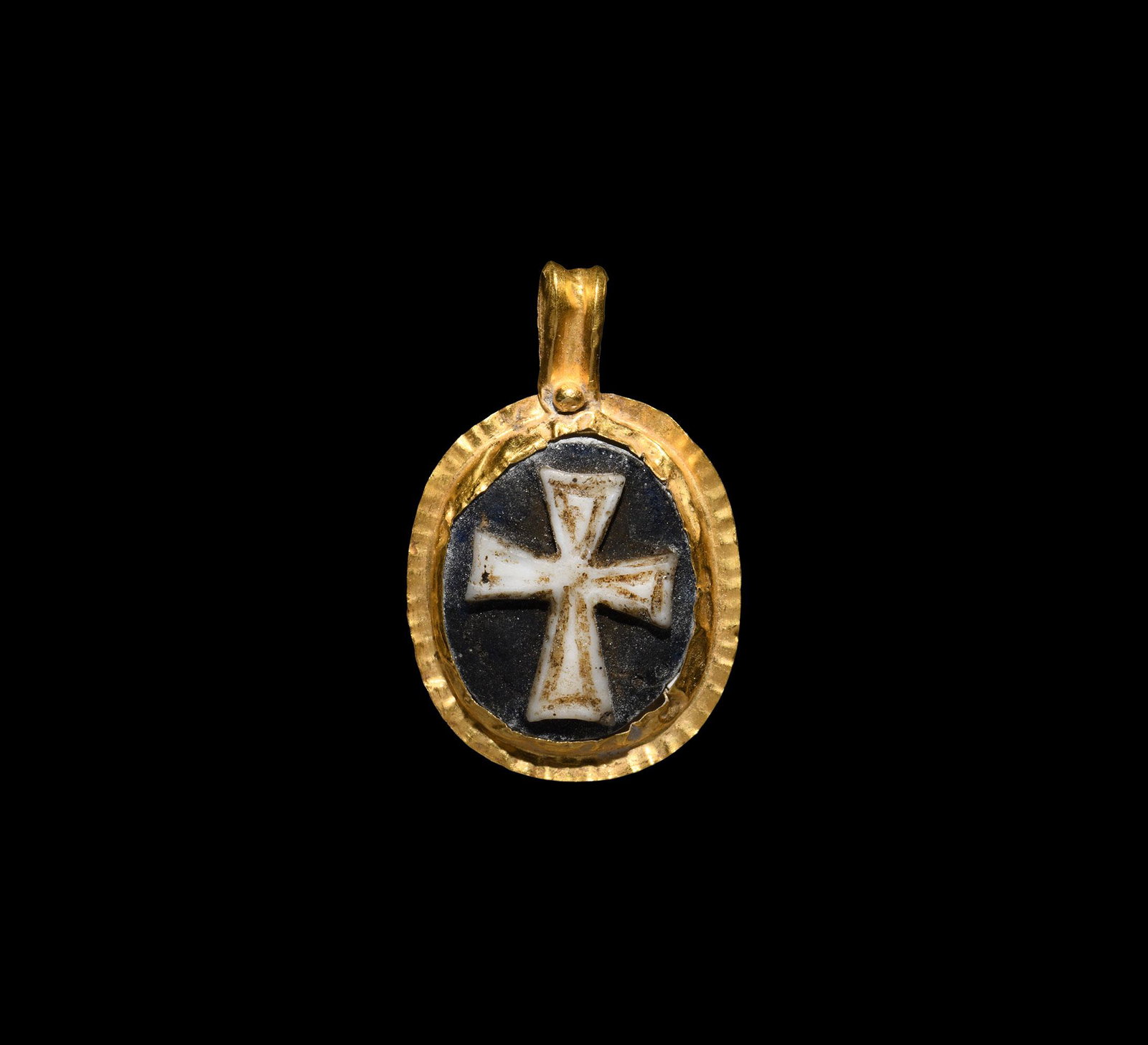Byzantine Glass Cameo with Cross in Gold Pendant: 6th-7th century AD. A gold pendant with crimped rim, ribbed loop with granule, central cell with glass panel, high-relief expanding-arm cross. 3.82 grams, 33mm (1 1/4"). Property of a London gentleman