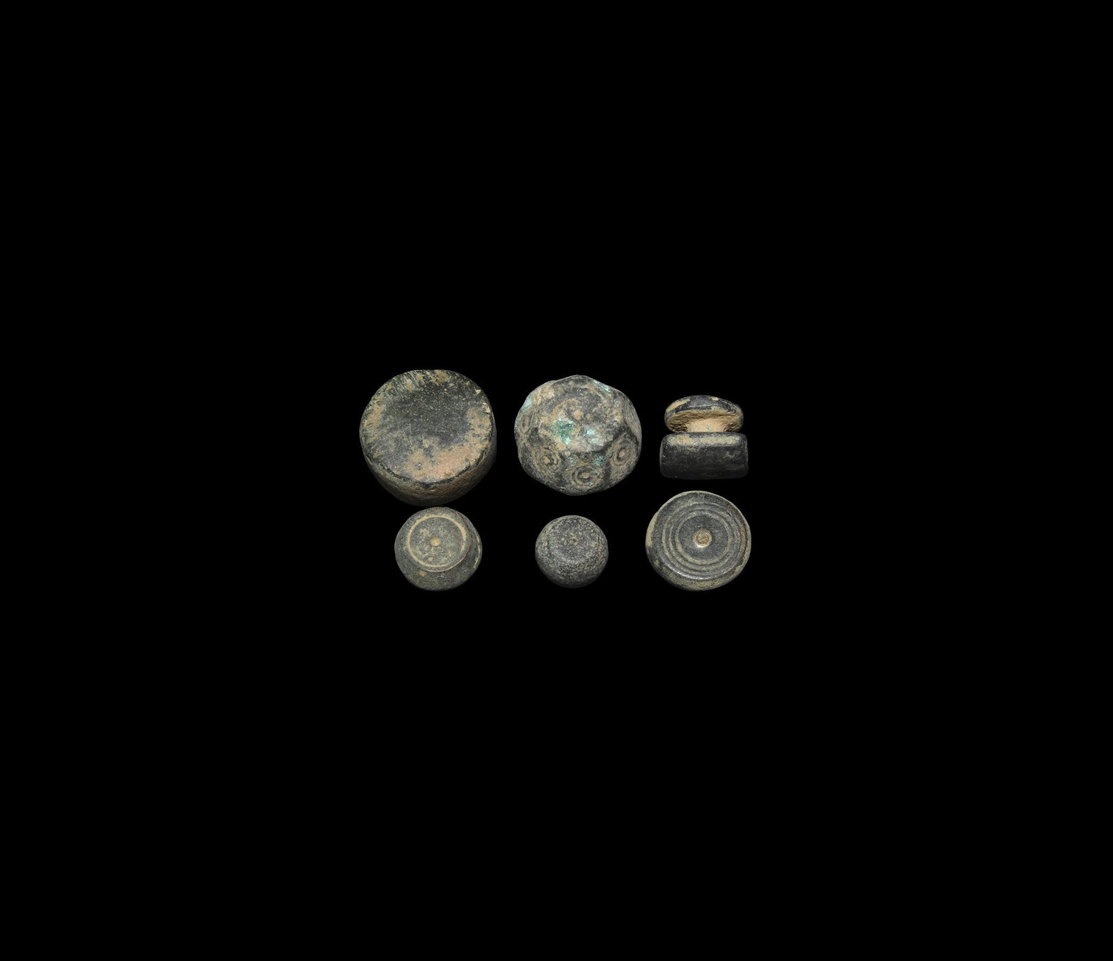 Byzantine Trade Weight Group: 6th-10th century AD. A group of six bronze weights comprising: two tabular; one biconical; one barrel-shaped; one facetted with ring-and-dot motifs; one rectangular with short handle. 89 grams total, 