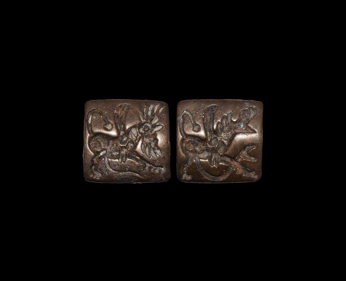 Double-Sided Seal with Winged Beasts: 1st millennium BC. A bronze pillow-shaped seal with intaglio gryphon to each broad face, pierced longitudinally for suspension. 18 grams, 22mm (3/4"). The Signo collection, the property of a West Lond