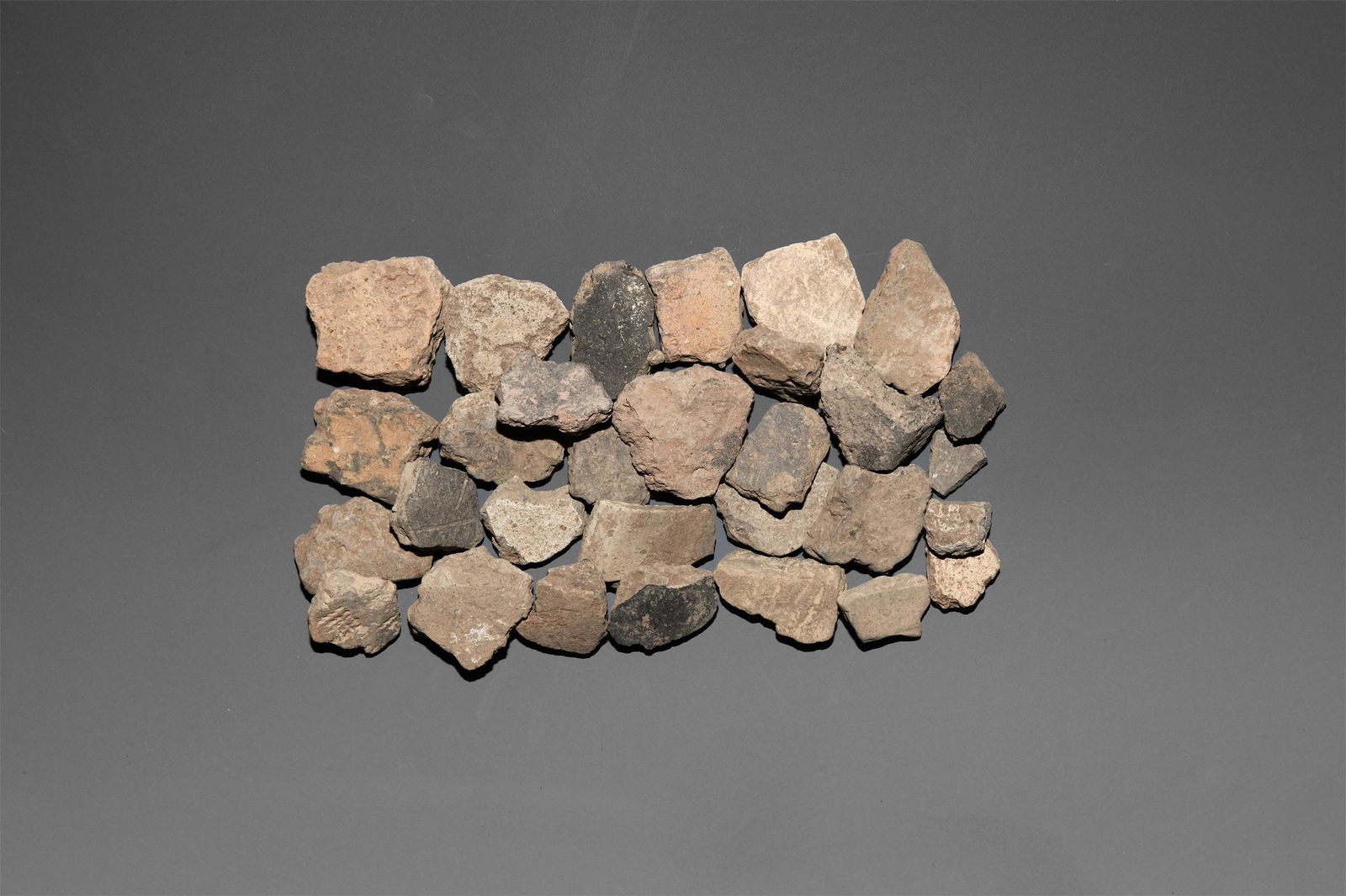 Stone Age Linear Band Ware Potsherd Group: Early Neolithic, 6th-5th millennium BC. A group of thirty potsherds, some partly ornamented. 299 grams total, 27-39mm (1 - 1 1/2"). From the Ullrich Collection, Germany; collected before 1980. [30, No