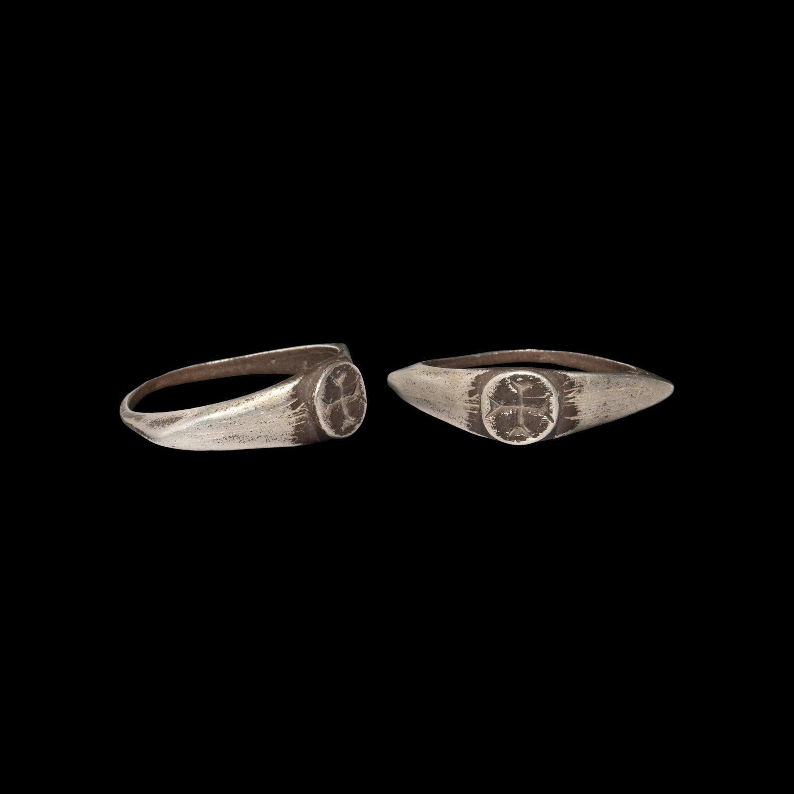 Medieval Silver Ring with Crusader Cross: 11th-13th century AD. A silver ring with keeled hoop, angled shoulders and raised circular bezel with an engraved equal-armed cross. 3.57 grams, 25.66mm overall, 18.94mm internal diameter (approximate