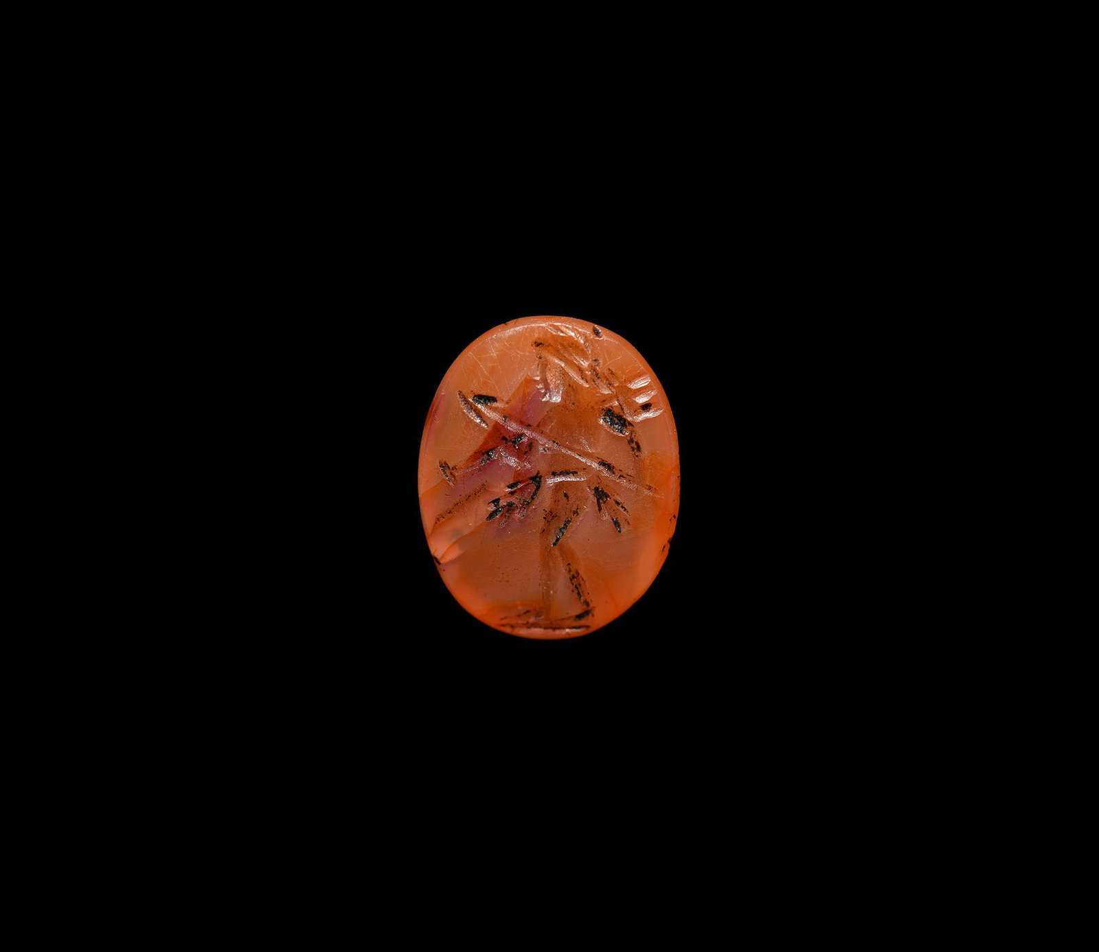 Roman Legionary Gemstone: 1st-2nd century AD. A carnelian gemstone with intaglio advancing legionary holding spear and trident. 0.74 grams, 12mm (1/2"). Property of a North London gentleman; previously in a private collection 