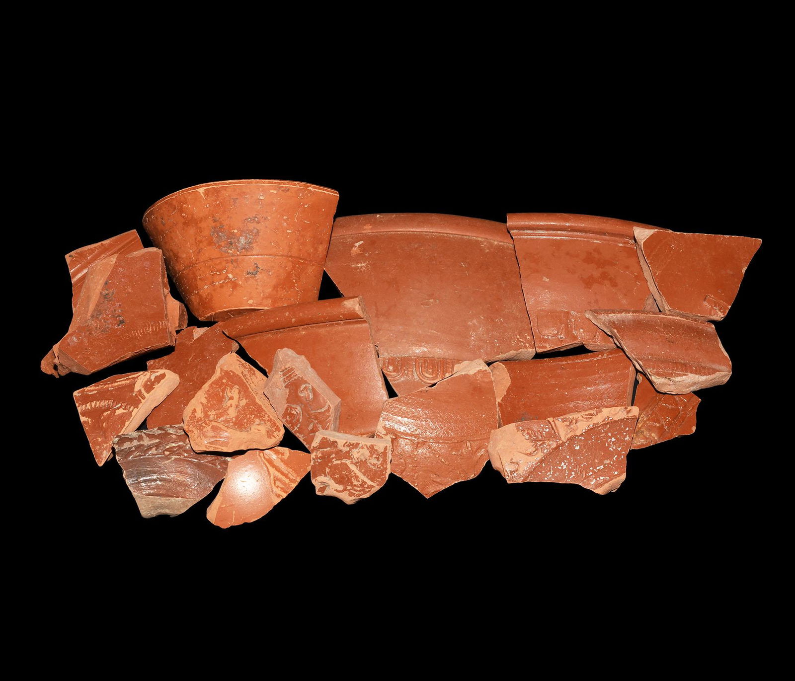 Roman Samian Sherd Collection: 1st-2nd century AD. A mixed group of Samian ware fragments, majority with moulded designs to the outer face. 305 grams total, 30-97mm (1 1/4 - 3 3/4"). Property of a London gentleman; acquired in the