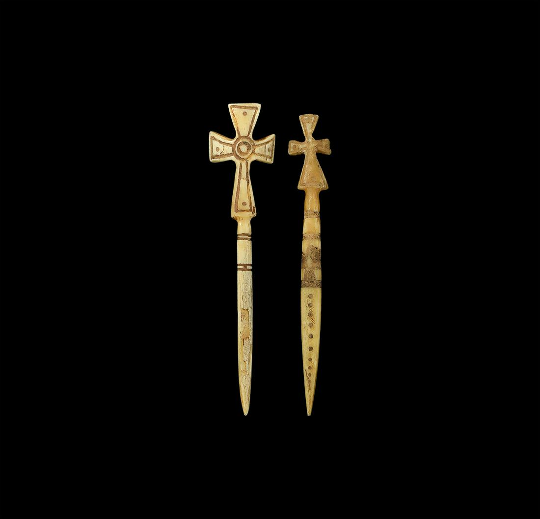 Byzantine Bone Cross Pin Group: 10th-12th century AD. A group of two bone dress pins, one with cruciform head and two pairs of incised lines, the other similar with additional details such as an eagle with wings spread and a column 