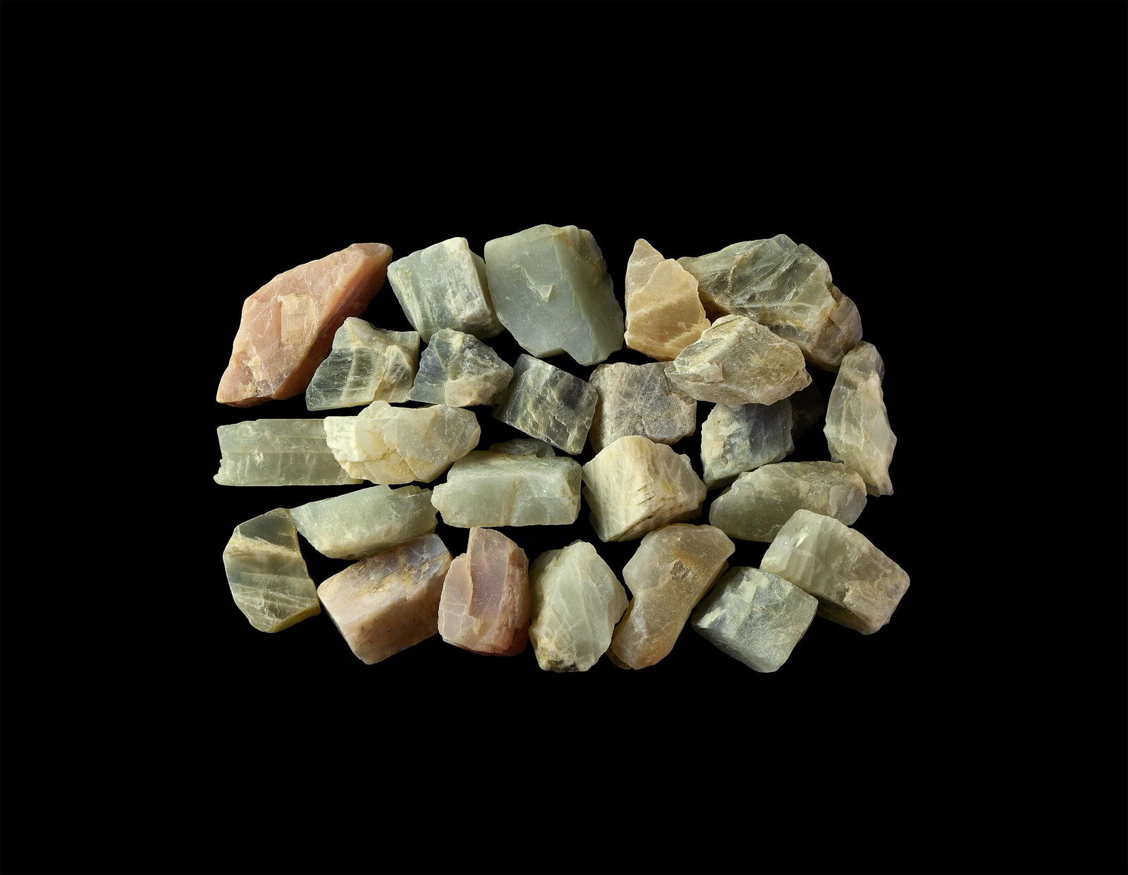 India Moonstone Mineral Specimens: A group of twenty-five unpolished moonstone specimens in various shapes and shades. 320 grams total, 22-53mm (1 - 2"). From the historic ‘Victorian Museum’ or later collection of Gregory, Bottley
