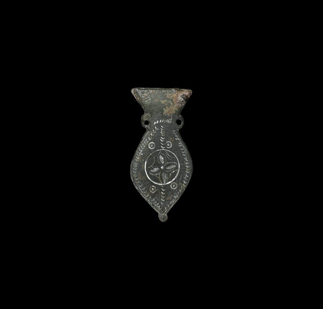Roman Amphora-Shaped Strap End: 4th-5th century AD. A bronze strap end formed as a stylised flat amphora with trumpet-style neck flanked by two lug handles, piriform body and knop finial; decorated on one face with floral and geomet