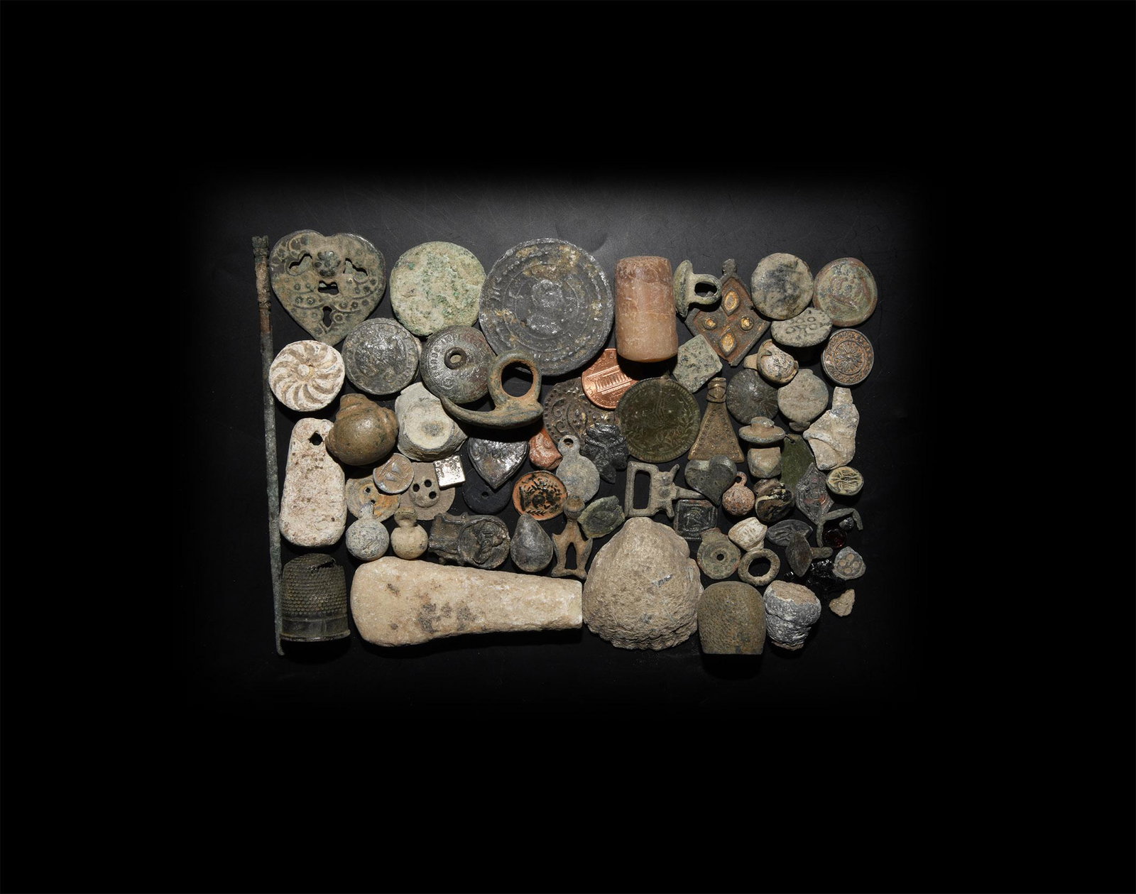 Roman to Post Medieval Artefact Group: 1st-20th century AD. A mixed group of sixty-six artefacts including a bronze bodkin; a beehive thimble; lead weights; a glass stopper with applied trails; two chessman seals; a flint arrowhead; a marb