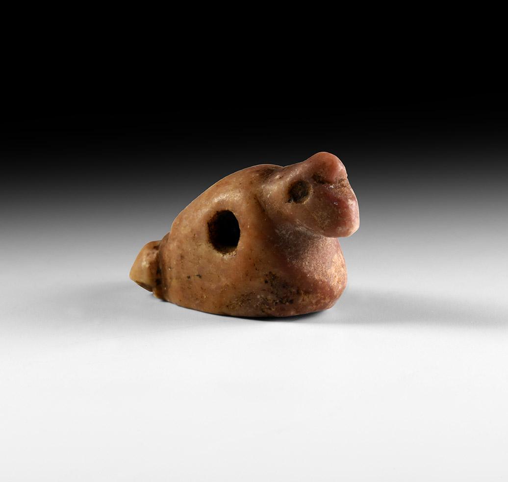 Bird Amulet: 1st millennium BC. A carved red jasper amuletic bead of a bird with comb and notched tail. 7.45 grams, 27mm (1"). From the collection of a Essex gentleman; formerly from a private Belgian collection;