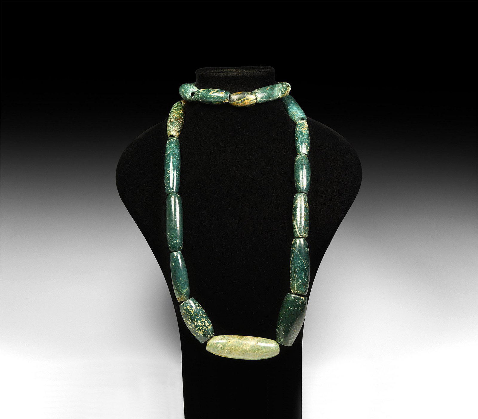 Pre-Columbian Large Jadeite Bead Necklace: 1st millennium AD. A group of twenty polished jadeite barrel-shaped fusiform beads; restrung in graduated series. 621 grams, 1.1m (43 1/4"). Property of a London gentleman; previously from a French pr