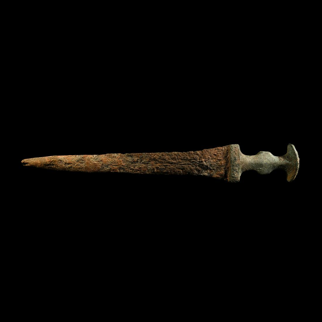 Luristan Iron Dagger: 9th-6th century BC. An iron dagger with a bronze ribbed hilt, comprising a splayed pommel and three horizontal grooves, rectangular guard; the triangular iron blade with shallow mid-rib tapering to th
