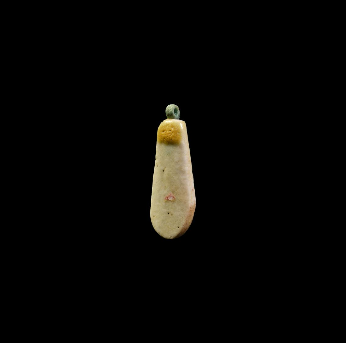 Egyptian Broad Collar Bead: New Kingdom, 18th Dynasty, Amarna Period, 1353-1336 BC. A cream-coloured glazed composition bead in the form of an elongated flower petal with orange detailing; suspension rings to the top and bottom.