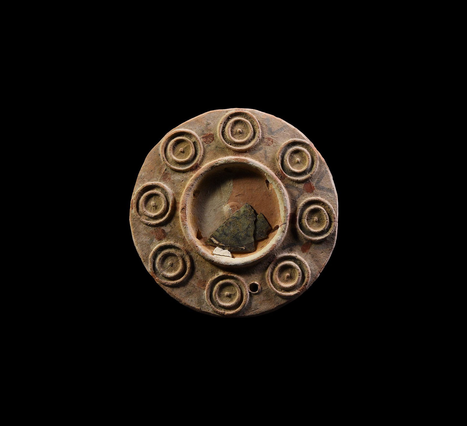 Byzantine Terracotta Mirror: 8th-10th century AD. A circular terracotta mirror with annular ornament to perimeter and small piercing to allow suspension, some mirror glass remains to central inset, the whole with original decorat