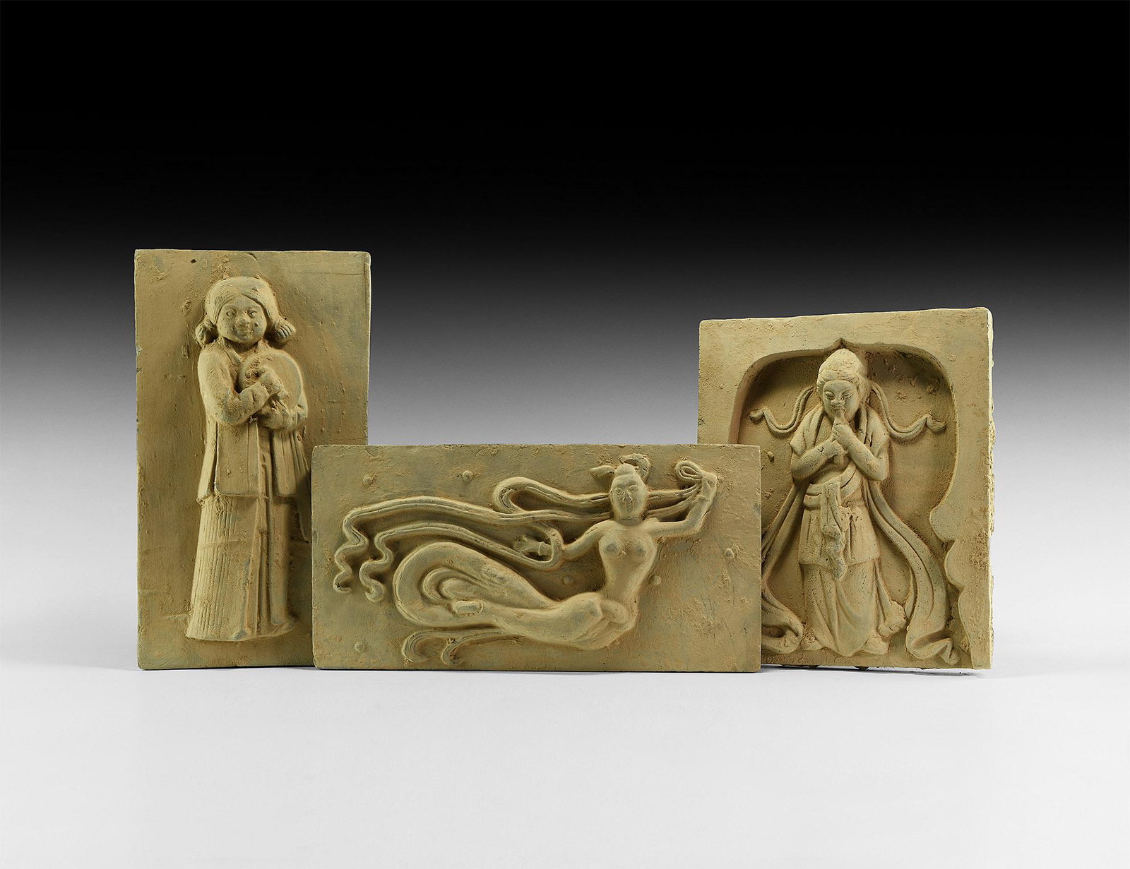 Chinese Song Tile Collection: Song Dynasty, 960-1127 AD or later. A group of three terracotta tiles comprising: a rectangular tile with a standing female dressed in a tunic and holding a musical instrument; a rectangular tile with