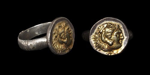 Greek - Alexander The Great Finger Ring: Circa 4th century BC. A silver-gilt finger ring comprising a D-section hoop with rosette on the lower face and incised banding equidistantly between this and the discoid bezel with raised bust of Alex