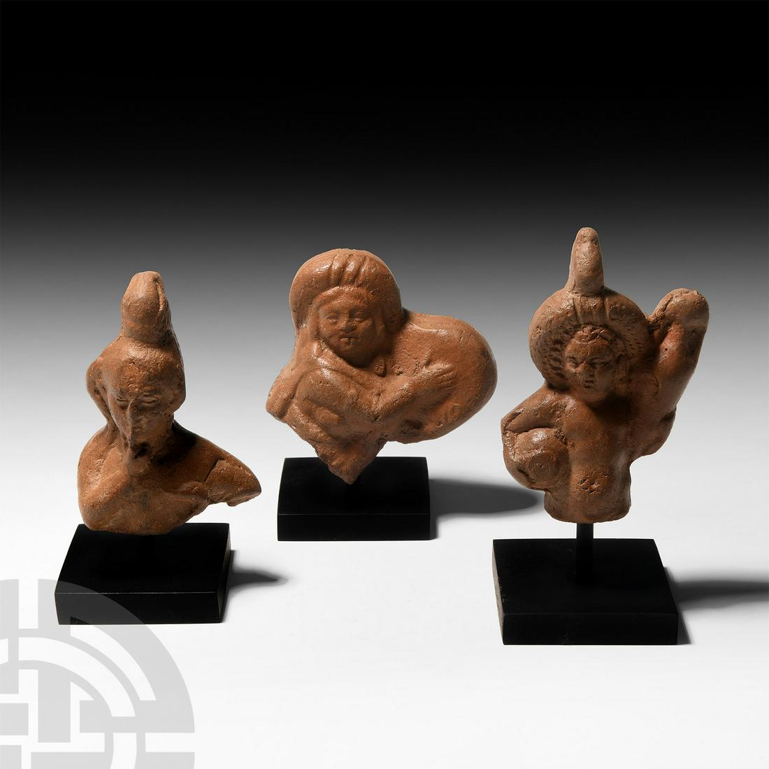 Roman Terracotta Figure Group: 2nd century A.D. A group of votive terracotta figures comprising: a naked dancer with tambourine (tympanum) and a high propoloma on the head; a naked boy holding an amphora on the left shoulder and a 