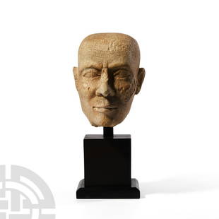 Romano-Egyptian Head of a Priest: Roman Period, 30 B.C.-323 A.D. A carved limestone head of a priest with shaven head, finely modelled facial features, aquiline nose and furrowed forehead; mounted on a custom-made stand. Cf. Andrews,