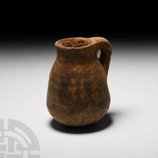 Egyptian Terracotta Juglet: Middle Kingdom, 2133-1797 B.C. or later. A terracotta juglet with piriform body, everted neck, integral handle and rounded base. 121 grams, 6.8 cm high (2 5/8 in.) From a 1940s collection. Brigantia