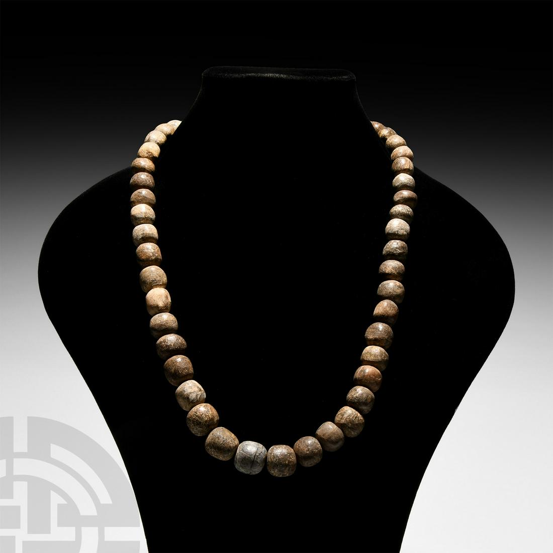 Mammoth Bone Bead Necklace String: Pleistocene Period, 110,000-12,000 B.P. A restrung necklace string of carved, oblate fossilised mammoth bone beads. 180 grams. 64 cm long (25 1/4 in.) From Siberia. Private Shropshire, UK, collection.
