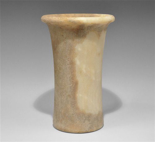 Near Eastern Bactrian Alabaster Vessel: Circa late 3rd-early 2nd millennium BC. Cylindrical in form, flaring to the slightly rounded base, with an overhanging rounded disc rim. Alabaster, 2.4 kg, 26 cm. UK art market, acquired prior to 2000
