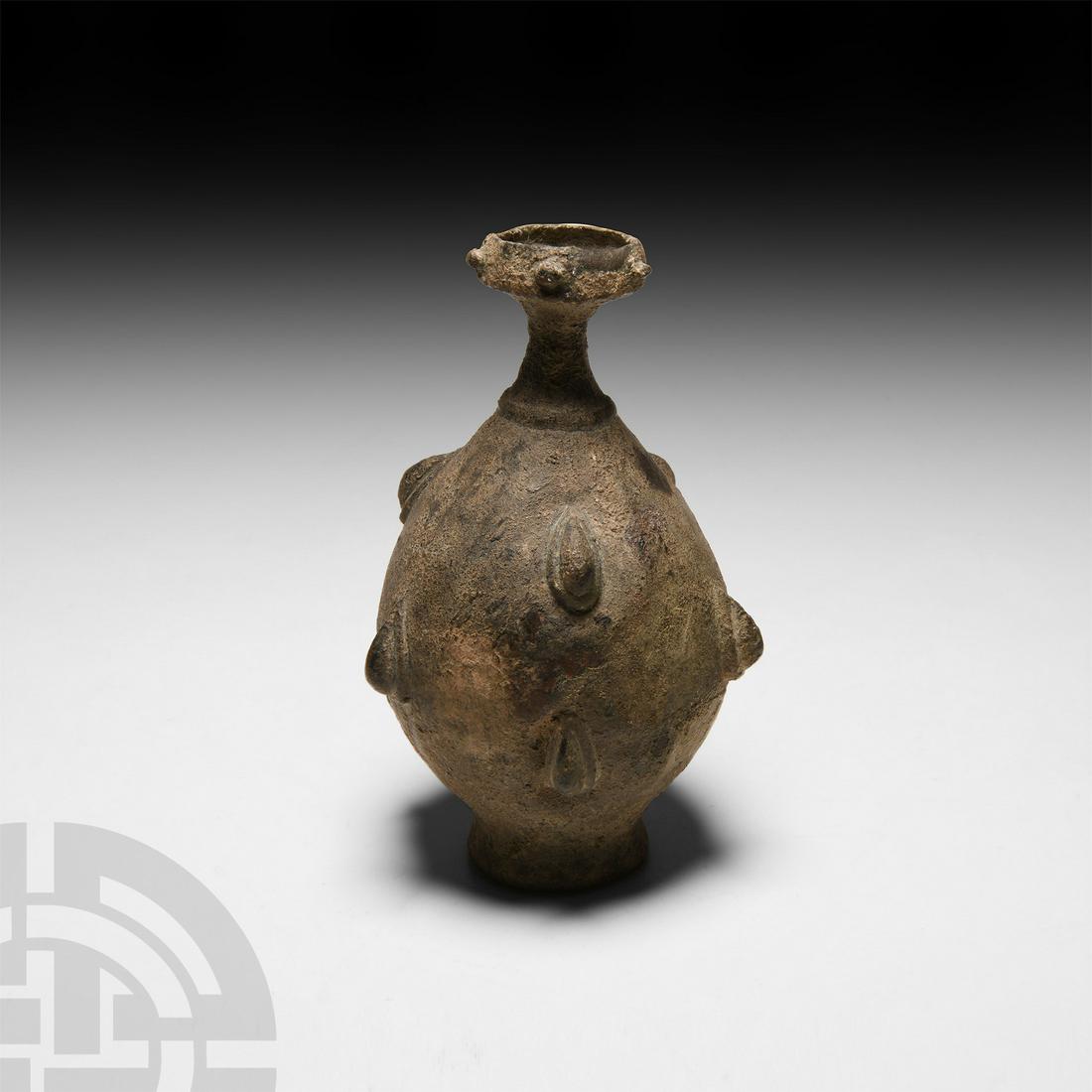 Sassanian Decorated Sprinkler Flask: 4th-5th century A.D. A piriform copper-alloy sprinkler flask with slender neck, inverted rim and integral foot, decorated with pellets and lobes. 136 grams, 11.1 cm high (4 3/8 in.). Acquired on the F